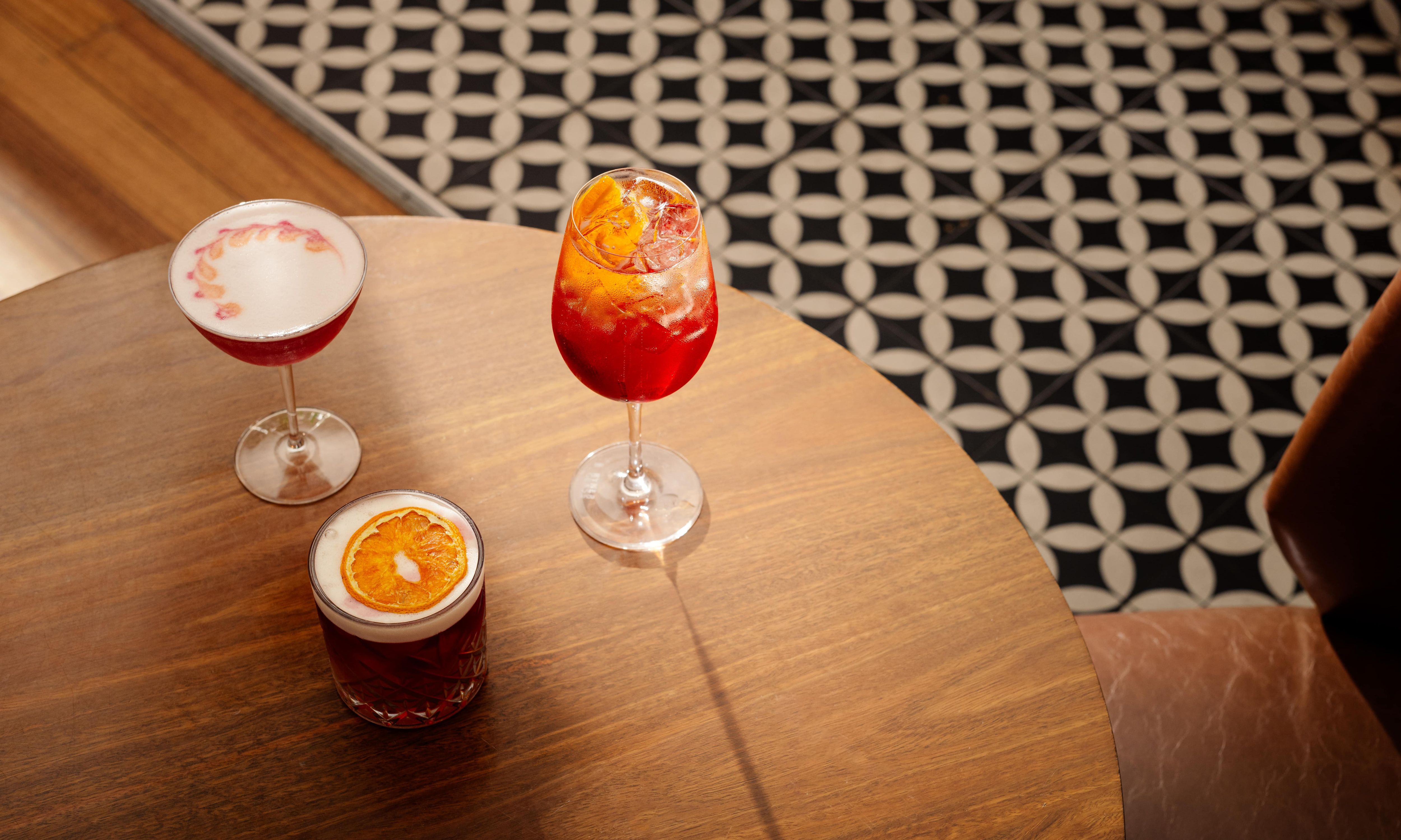 Three cocktails placed on a low table